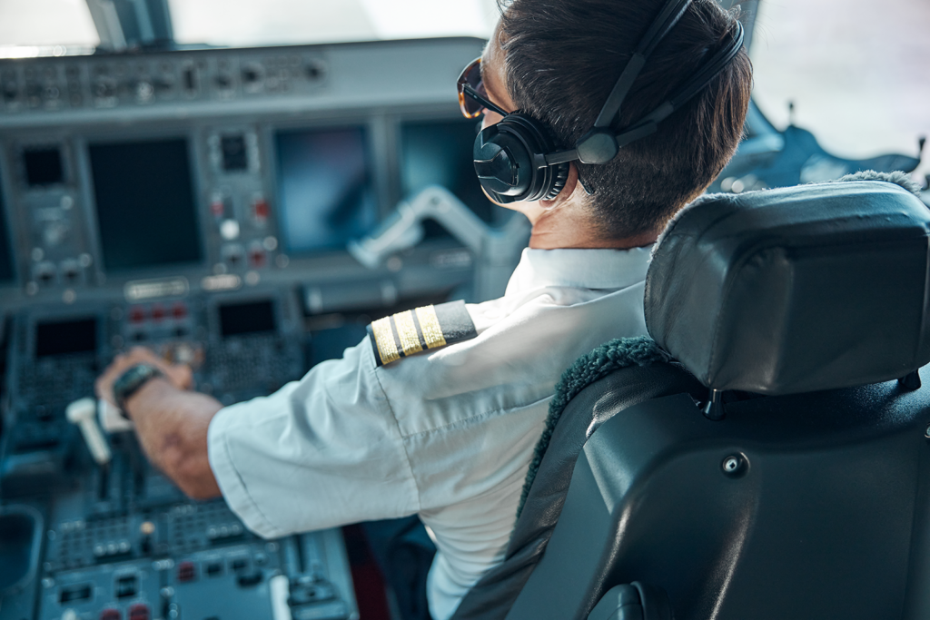 Veteran Air Warriors pilot sitting in cockpit of airplane with headset on.