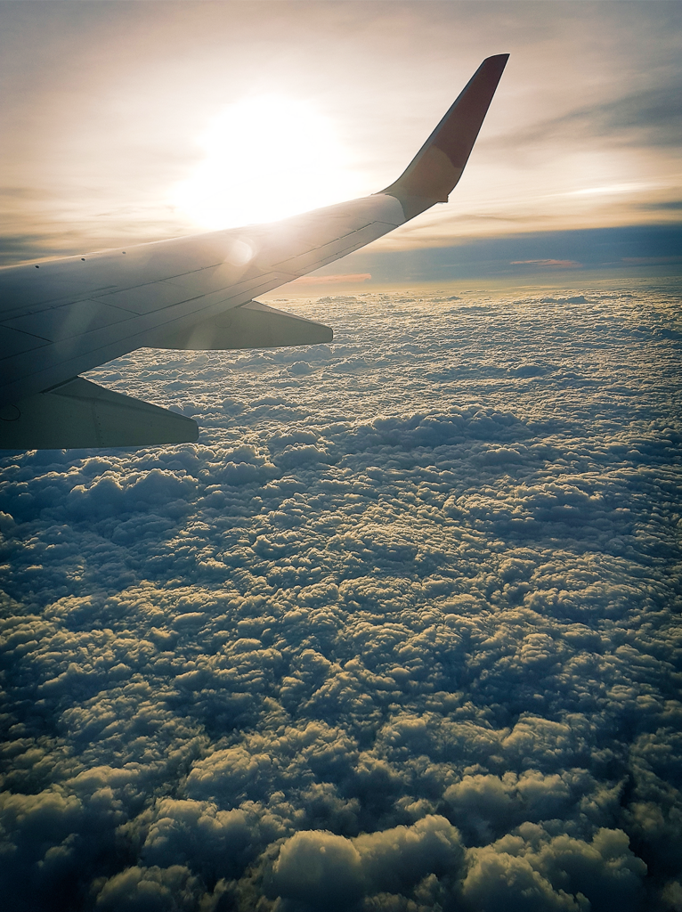 Veteran Air Warriors view of the airplane wing as airplane flys over the clouds.