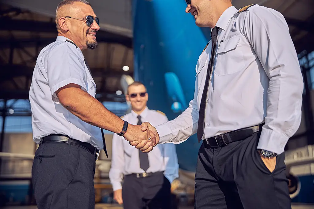 Veteran Air Warriors Two pilots shake hands outside.